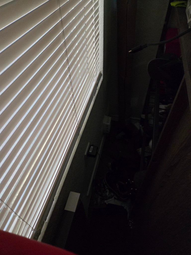 Dark window corner where the AT&T modem sits with cables and a power brick